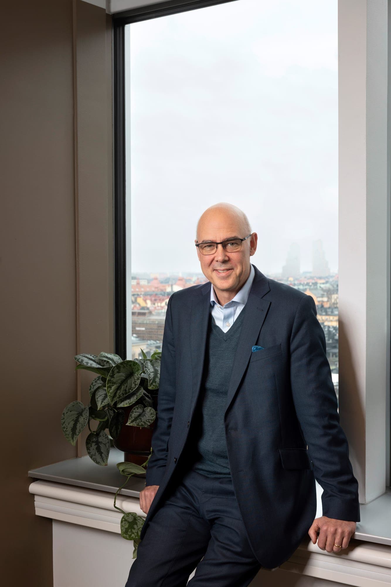 A senior specialist standing by an office window